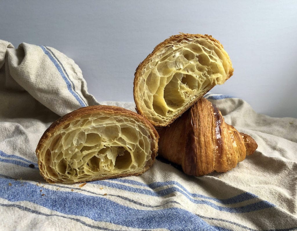 Biting into Batard Boulangerie's croissant for the best croissant in Vancouver