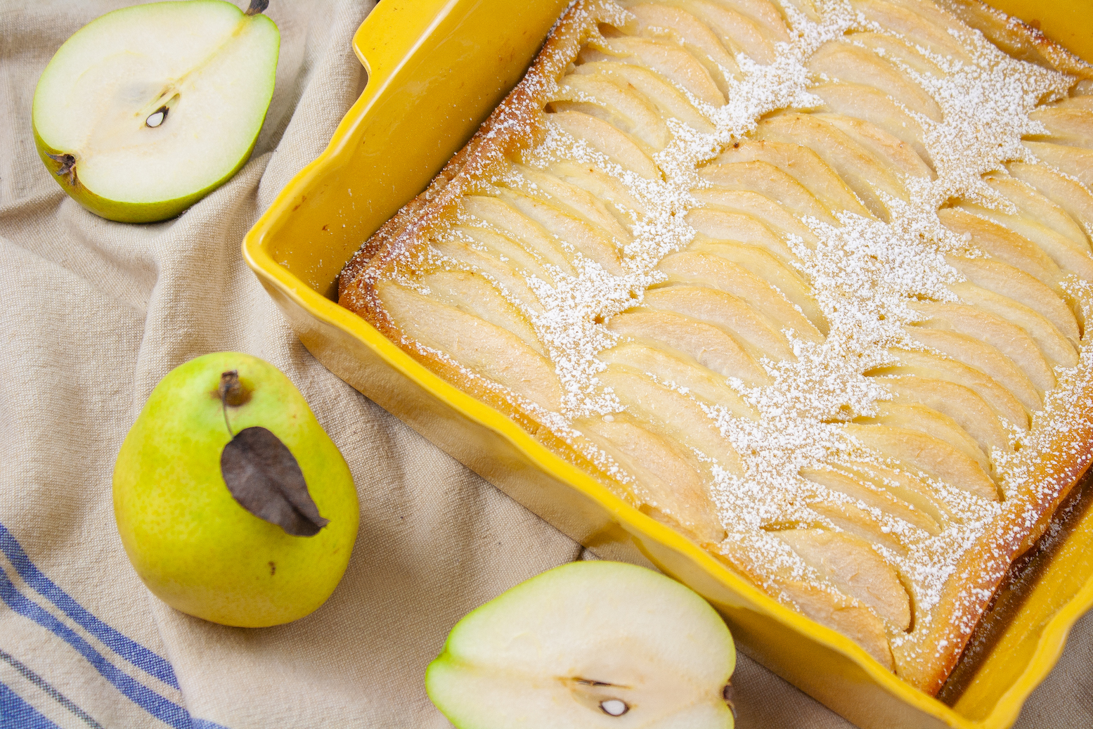 This is a picture of a pear clafoutis in a yellow baking dish
